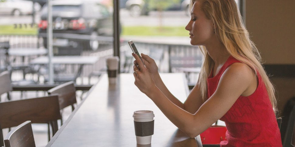 Frau mit Smartphone im Caffe