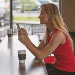Frau mit Smartphone im Caffe